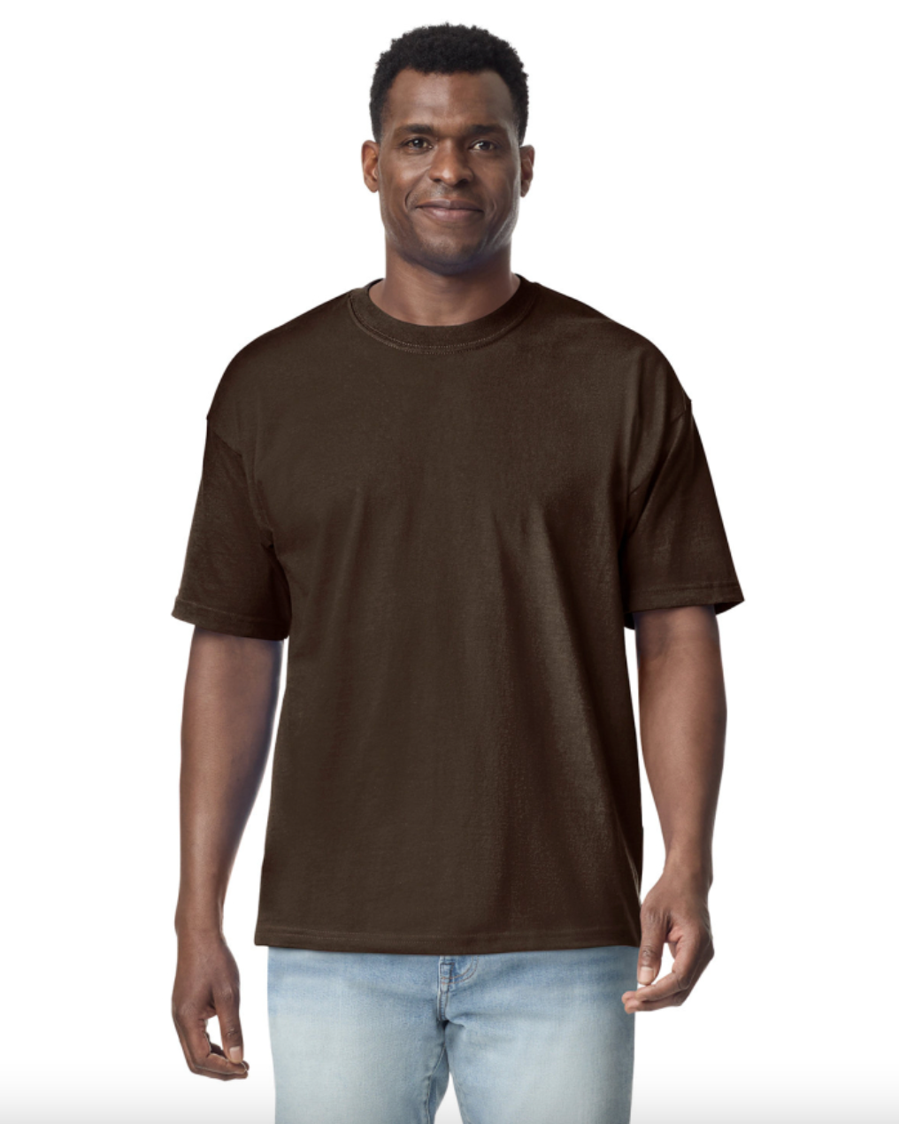 Man wearing a brown t-shirt and light blue jeans on a white background