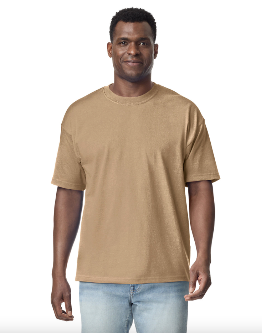 Man wearing a beige t-shirt and light blue jeans on a white background