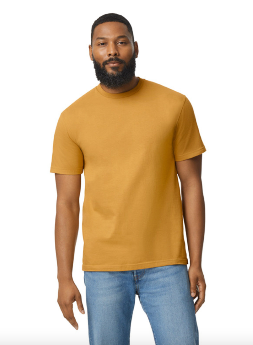 Man wearing a mustard yellow t-shirt and blue jeans on a white background